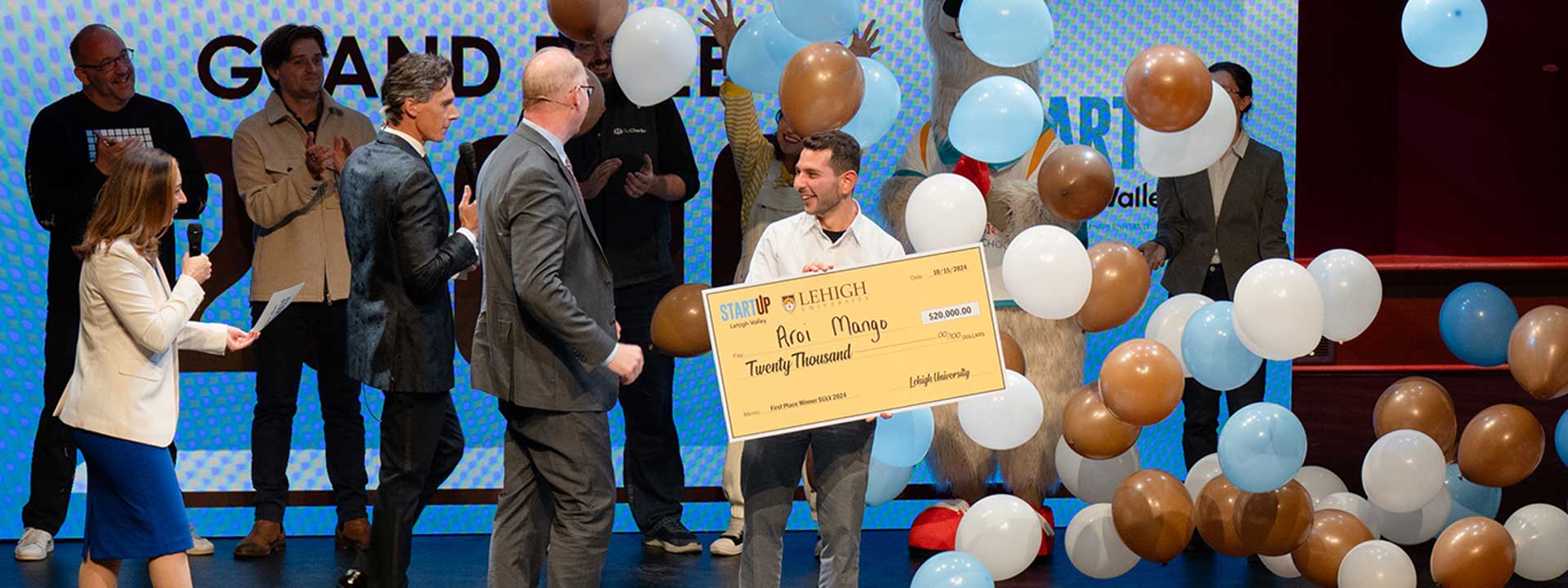 StartUp Lehigh Valley 2024 Winner holding a large check and surrounded by balloons